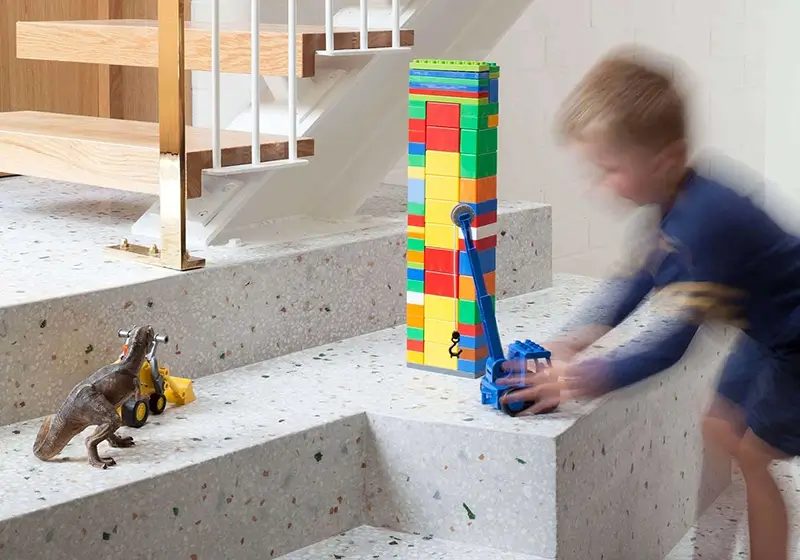 child playing in hallway on marble stone steps